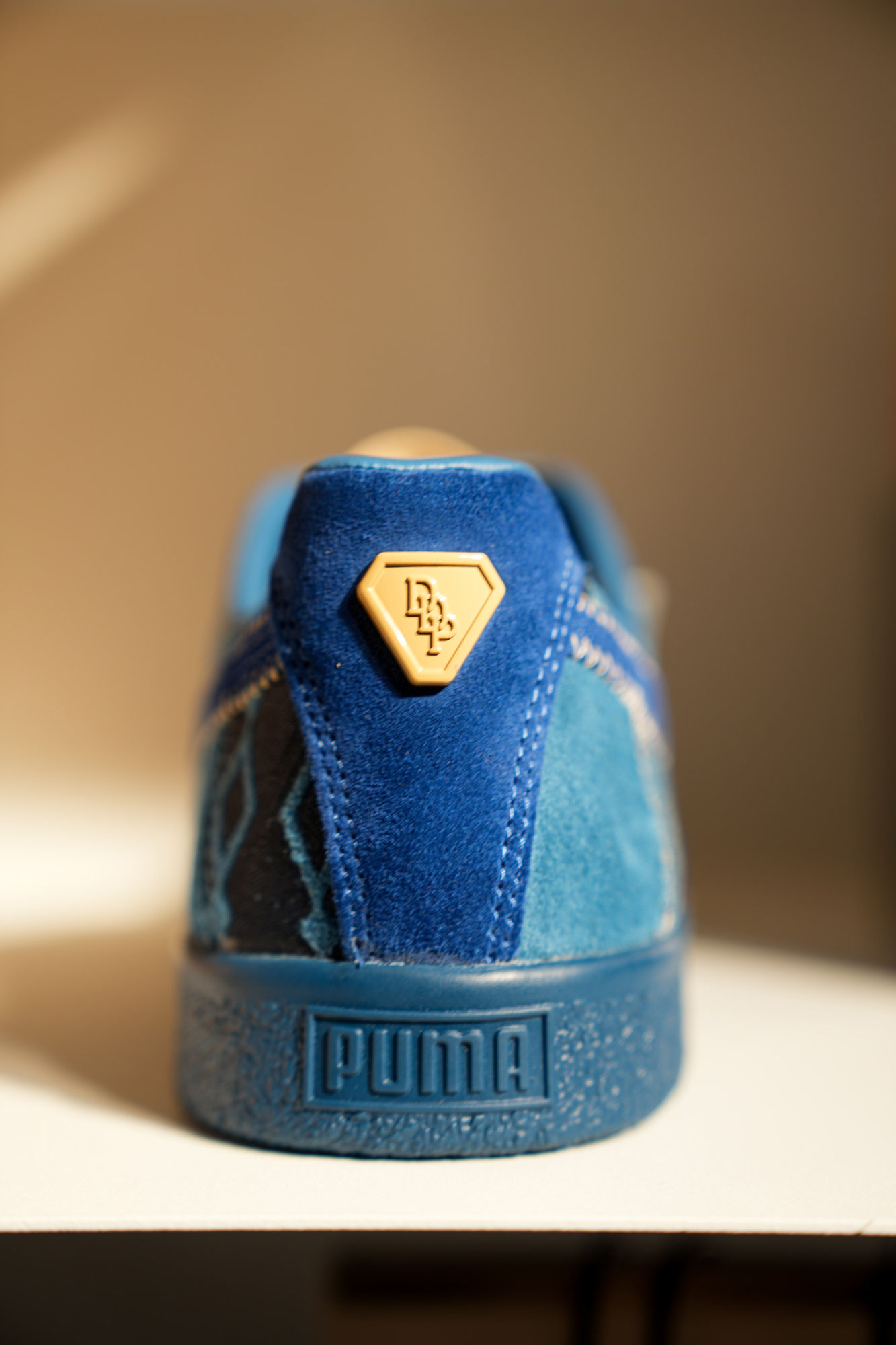 Product detail of a PUMA × Dapper Dan sneaker heel with gold hardware