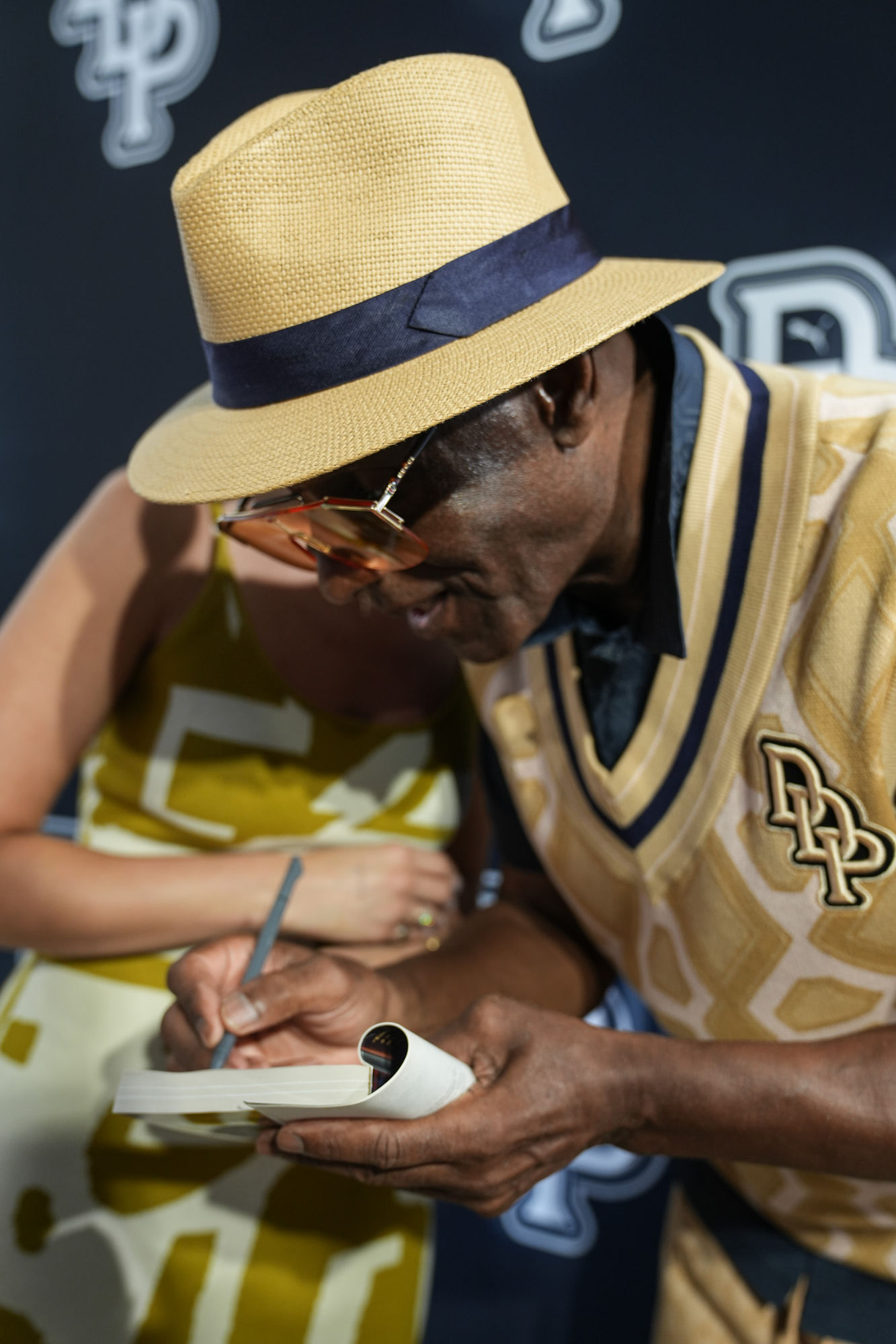 Dapper Dan signing merchandise for a guest at the PUMA launch